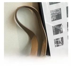 Detailed close-up of wide khaki litchi grain leather handle with reinforced stitching