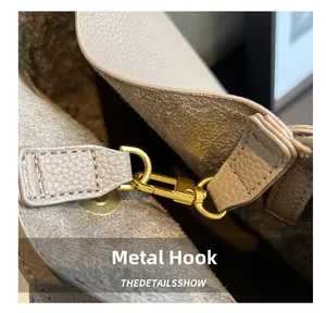 Detailed macro view of premium golden hardware hook on lychee pattern leather handbag
