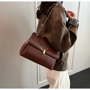 Détail du sac cabas vintage marron foncé avec boucle métallique dorée et bandoulière chaîne