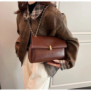 Détail du sac cabas vintage en cuir marron avec chaîne dorée et boucle en métal