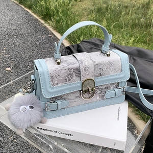 Sac à main en brocart bleu clair avec motif phénix et breloque monstre en peluche sur livres