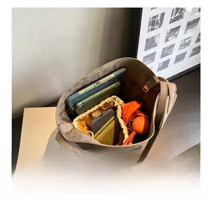 Top view showing large capacity bucket bag interior with items like iPad and cosmetics