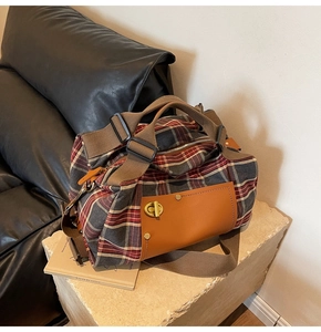 Close-up of vintage plaid canvas travel bag with leather trim and metal twist lock