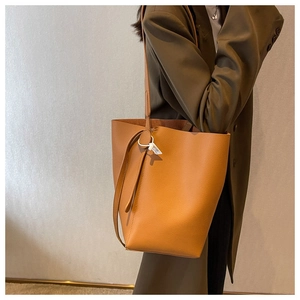 Brown leather bucket bag with large capacity shown in a stylish autumn outfit style