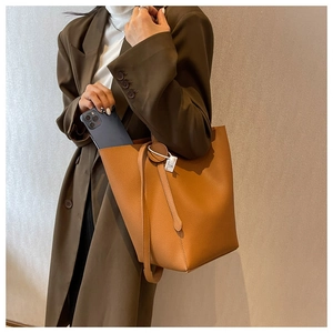 Detail shot of the brown litchi grain leather bucket bag showing spacious interior capacity
