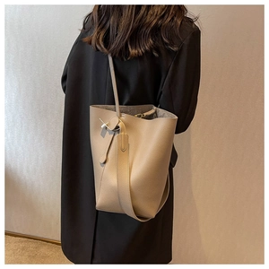 Detailed back view of a minimalist khaki bucket bag showing size and shoulder drape
