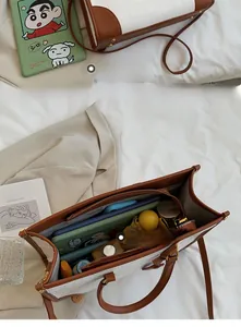 Macro view of interior storage capacity in textured two-tone leather tote bag