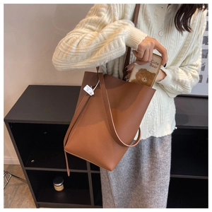 Close-up of brown litchi pattern leather bucket bag showing spacious interior capacity