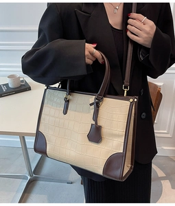 Detail of crocodile embossed large tote bag with brown leather handles and strap
