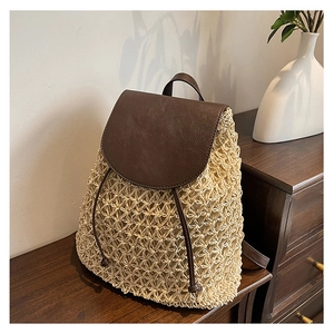 Detail of woven straw backpack with brown leather flap and drawstring closure