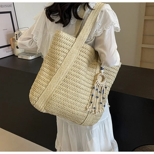 Détail du grand sac cabas en paille avec pampille œil bleu et bandoulière tissée