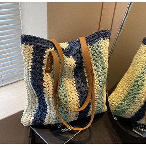 Detail der blau-weiß gestreiften gewebten Strandtasche mit Ledergriffen bei natürlichem Licht