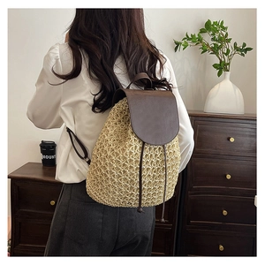 Detail of hand-woven straw backpack with brown leather flap and drawstring closure