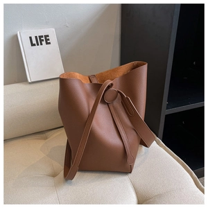 Detail view of caramel brown bucket bag with lychee grain texture and drawstring