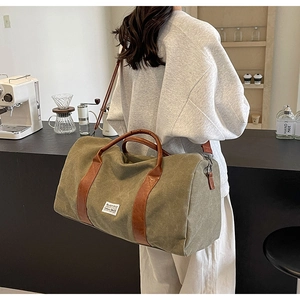 Détail du sac de voyage en toile vert armée avec sangles en cuir et étiquette BLACK RICE