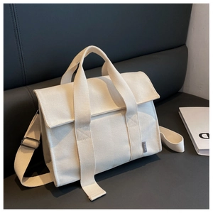 Detailaufnahme der cremefarbenen Canvas-Tasche mit verstellbarem Gurt und SJCH-Logo