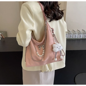 Detail der rosa Hobo-Tasche mit Perlenkette, Schmetterlingsdeko und Plüschanhänger