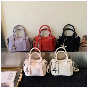 Détail de sacs Boston en cuir de diverses couleurs avec pendentifs étoiles sur socle