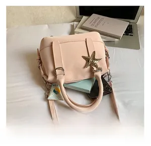 Détail de la capacité intérieure du sac rose avec charme en forme d'étoile argentée