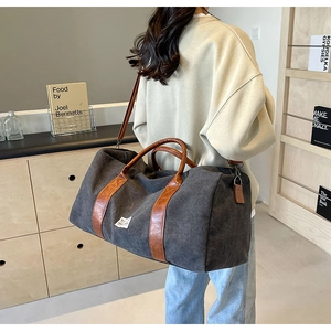 Détail du sac de voyage en toile grise avec sangles en cuir et grande capacité pratique