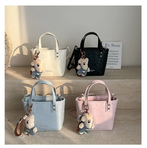 Détail de sacs seaux élégants en quatre couleurs avec pendentifs ours mignons