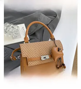 Detail view of brown vintage handbag with herringbone flap and metallic twist lock closure