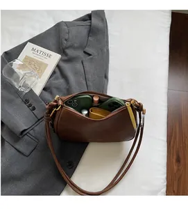 Detail view of brown leather bag interior showing space for two phones and lipstick