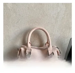 Détail de la poignée du sac à main rose clair avec boucles argentées et breloque étoile