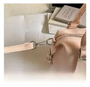 Détail du crochet en métal argenté et de la bandoulière du sac boston rose pâle