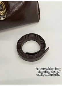 Detail of adjustable long shoulder strap and vintage brown oil wax leather of the handbag