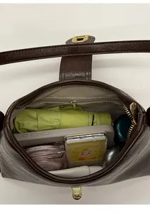 Interior storage view of a vintage brown shoulder bag with daily essentials inside