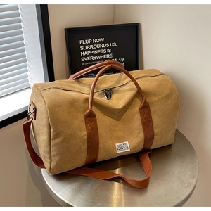 Vue détaillée du sac de voyage en toile kaki avec sangles en cuir et boucles en métal
