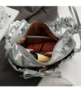 Détail macro du compartiment intérieur spacieux du sac à main argenté plissé à nœud