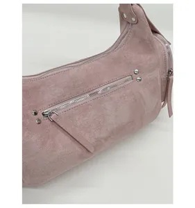Detail of pink matte dumpling bag showing the side zipper pocket and silver metal hardware