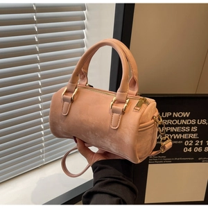 Détail du sac Boston rose avec texture mate, ferrures dorées et fine bandoulière