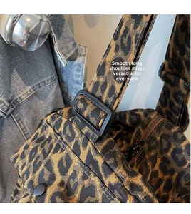 Detail of leopard print canvas bag showing the adjustable black shoulder strap and buckle