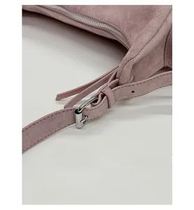 Detailed macro view of silver metal buckle and frosted leather texture on mauve handbag