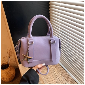 Gros plan d'un sac à main violet en cuir avec un détail de breloque étoile de mer en métal