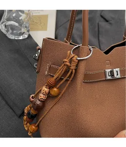 Detail of vintage canvas tote with leather straps and unique wooden bead charm