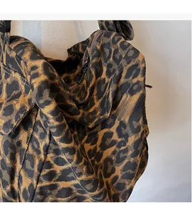 Close-up of leopard print canvas tote showing metal zipper detail and soft fabric texture