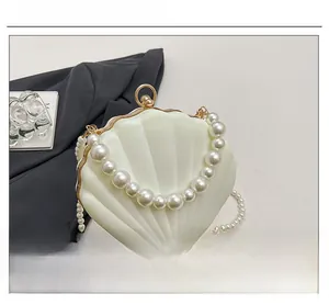 Detailed macro view of the glossy shell shaped acrylic evening bag with pearl handle