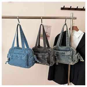 Detailed shot of vintage denim handbags in light blue, dark grey, and washed blue colors