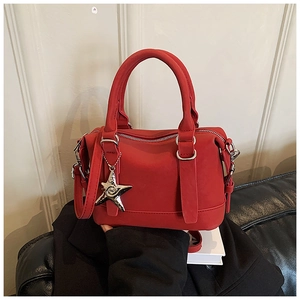 Détail du mini sac Boston rouge en cuir avec breloque étoile et bandoulière assortie