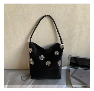 Detail of black velvet shoulder bag with silver sequin flowers and chain strap