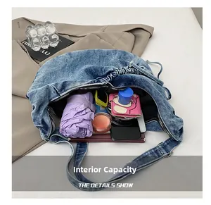 Internal capacity of denim crossbody bag showing space for phone, umbrella, and wallet