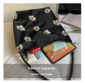 Internal capacity of velvet shoulder bag showing tablet, books and cosmetic items