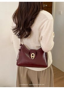 Deep wine red retro underarm bag with gold twist lock worn by a model from the back