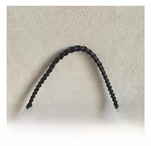 Detail view of a black tote bag featuring a woven handle and sparkling silver sequins