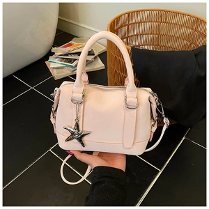 Détail du sac Boston rose montrant la texture mate et le pendentif étoile de mer argenté