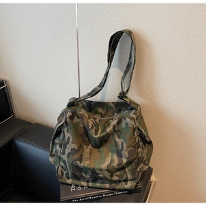Detail view of large camouflage canvas tote bag on a leather sofa for casual use